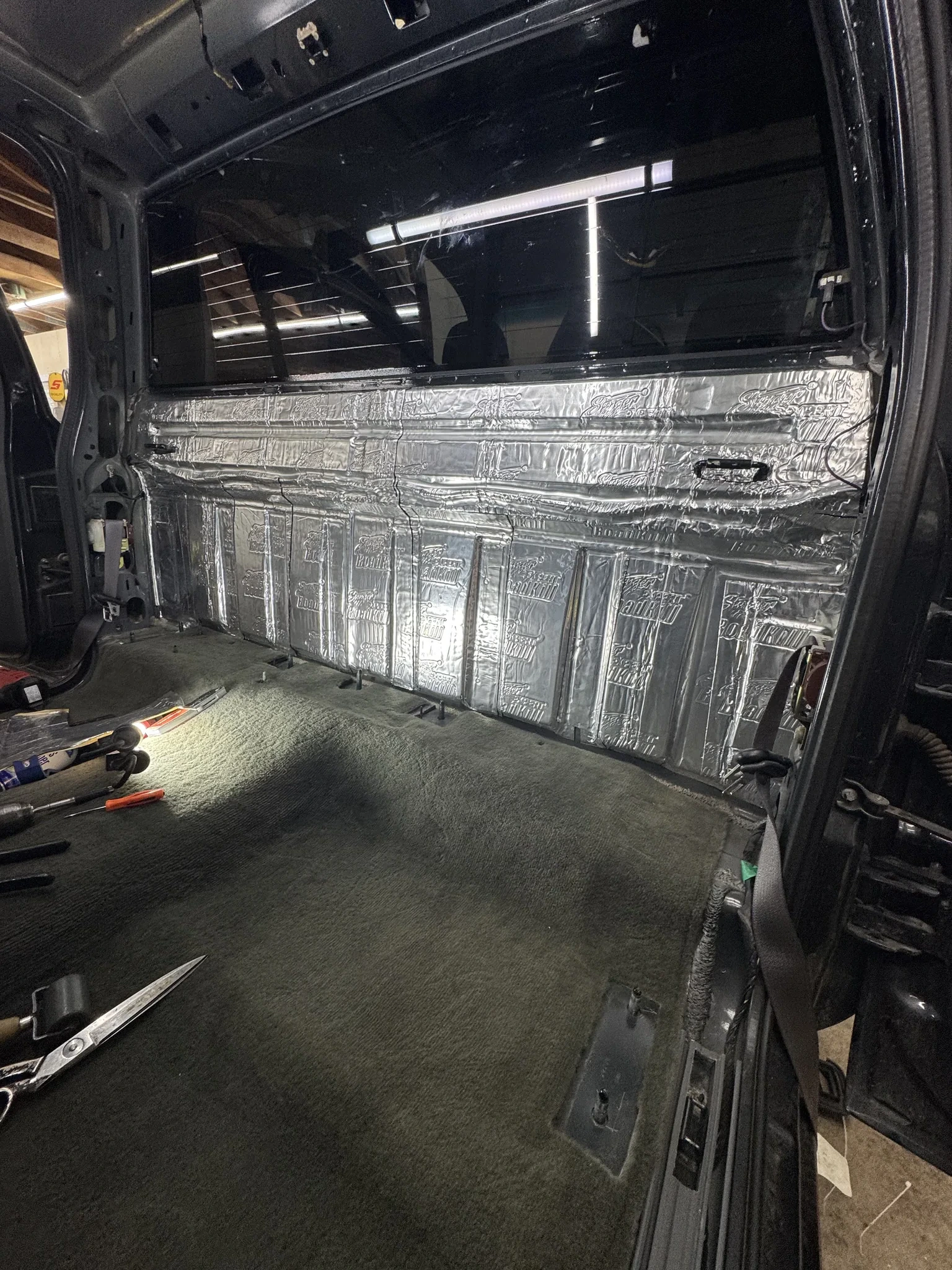 Rear cab wall of Silverado fully covered in two layers of Stinger RoadKill sound deadening